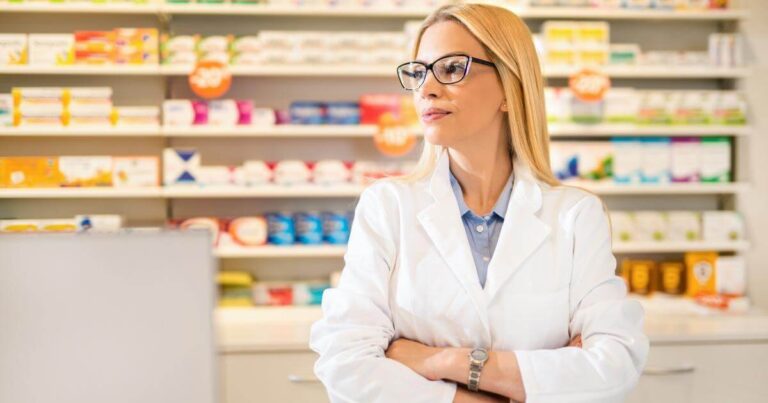 pharmacist with arms crossed and neutral expression, looking away from camera