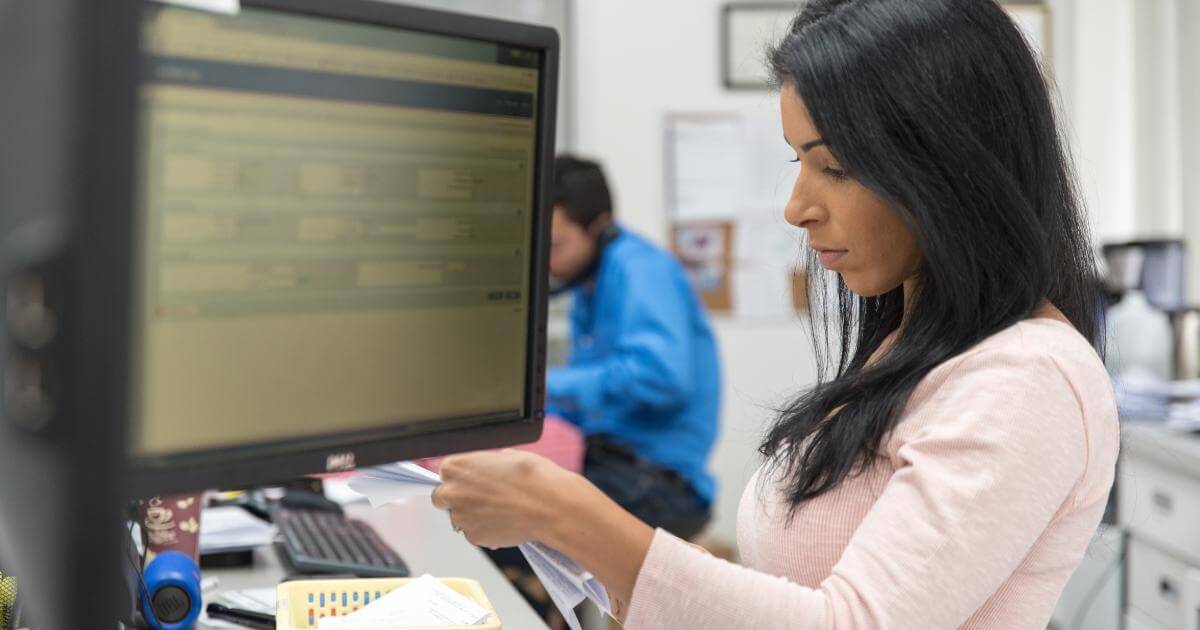 busy pharmacy technician with monitor in foreground
